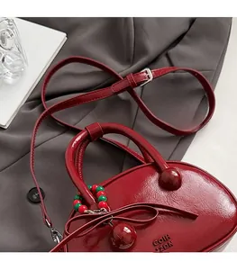 Deep red patent leather bowling bag with bead charms and adjustable shoulder strap