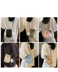 Detail view of colorful nylon crossbody bags with drawstrings and plush charms