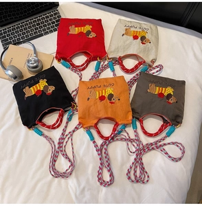 Detail of five colorful nylon bucket bags with cute dachshund embroidery and woven straps