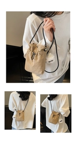 Detail of khaki drawstring crossbody bag with cute plush cat charm and black shoulder strap