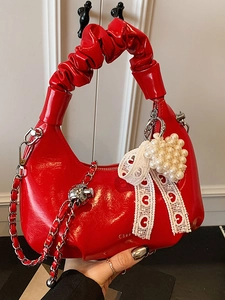 Sac à main rouge en cuir verni brillant avec anse plissée et pendentif cœur