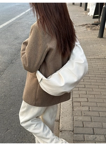 Detail showing soft pleated texture and ivory white leather finish on crossbody bag