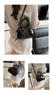 Close-up of black glossy mini bowling bag with bow and colorful beaded charm detail