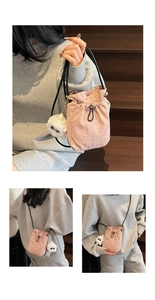 Detail of light pink drawstring bucket bag with a cute white plush sheep pendant