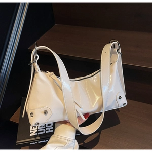 Detailansicht der weißen Lackleder-Tasche mit silbernen Nieten und schwarzem Reißverschluss