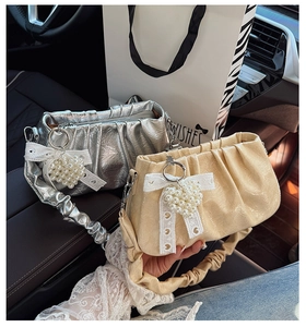 Détail du petit sac carré plissé avec pendentif cœur en perles et nœud en dentelle chic