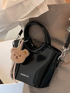 Borsa a secchiello nera lucida alla moda con manici tondi e ciondolo orsetto di peluche