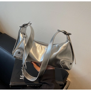 Detail der silbernen Metallic-Unterarmtasche mit Spiegeleffekt und Nietendekoration
