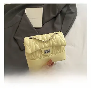 Detail showing the light yellow quilted PU leather bag with silver chain and metal lock