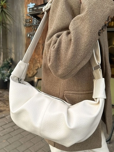 Minimalist white croissant shoulder bag with pleated leather texture in street style