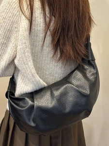 Chic black pleated croissant shoulder bag with lychee texture in a minimalist casual look
