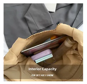Interior detail of a large khaki straw tote bag showing spacious capacity and zip pocket