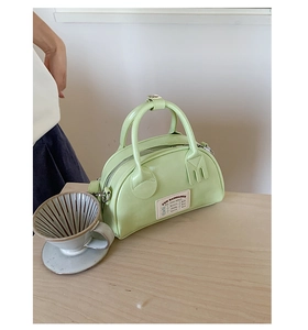 Dettaglio della borsa Boston verde con cerniera argentata e hardware a forma di forchetta