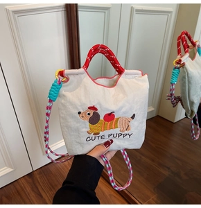 Close-up of cute dachshund embroidery and colorful braided straps on a beige bucket bag