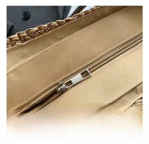 Detailed macro view of the smooth metal zipper and canvas lining on a straw tote bag