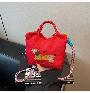 Close-up of cute puppy embroidery and woven handles on a red mini bucket bag