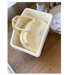 Dettaglio mini borsa bowling giallo crema con zip argentata e etichetta FUN