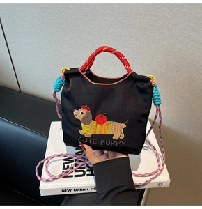 Detailed close-up of cartoon puppy embroidery on black crossbody bucket bag