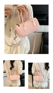 Detail of pink pleated cylinder bag showing vertical textures and silver metal zipper