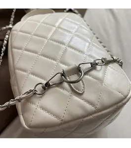 Close-up of elegant cream white quilted leather and silver metal chain details