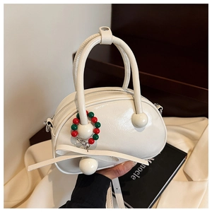 Detail of white patent leather bowling bag with glossy finish and decorative round beads