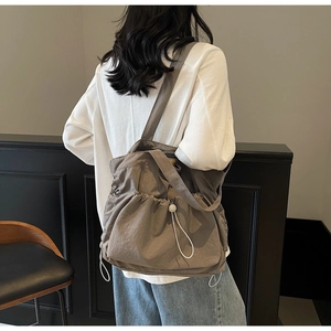 Detail of coffee brown drawstring canvas tote bag showing soft texture and side pocket