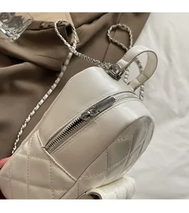 Detailed close-up of white quilted leather bag with premium silver metal zipper and chain