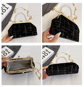 Vue détaillée du sac en velours noir avec motif géométrique doré et poignée perle