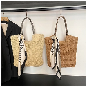 Detail of woven straw tote bags with striped scarves hanging in a stylish wardrobe