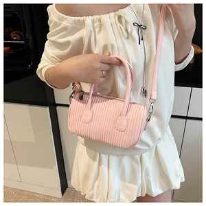 Detailed view of pink pleated barrel bag with top handle and detachable strap in PU