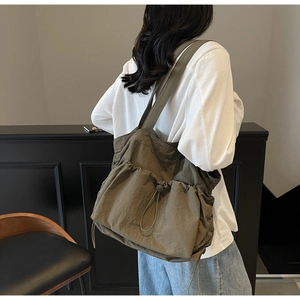 Detail of khaki oversized tote bag with drawstring texture and long shoulder strap