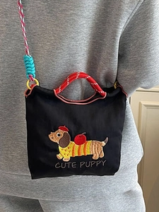 Black canvas bucket bag with cute dachshund embroidery and colorful woven straps
