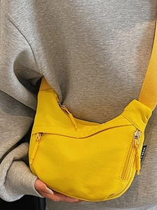 Minimalist bright yellow nylon half-moon crossbody bag with wide shoulder strap