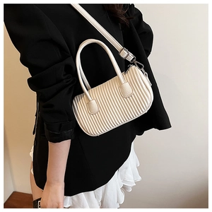 Detail view of cream-colored pleated crossbody bag with fine vertical texture