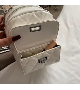 Detail of white quilted backpack showing front pocket storage for lipstick and makeup