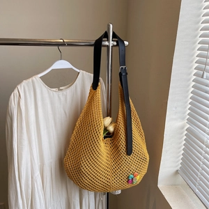 Detail of yellow hand-crocheted hollow mesh tote bag with colorful 3D floral accents