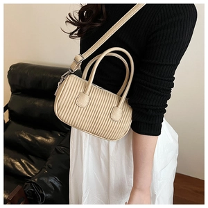 Detail of beige wrinkled leather handbag showing textured pleats and sturdy handles