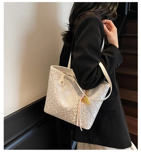 Detail of white jacquard tote bag with floral patterns and pink silk scarf accessory