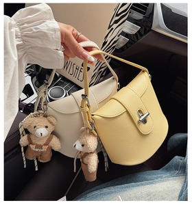 Detail of minimalist leather shoulder bags with metal locks and cute bear charms