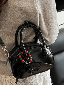 Minimalist black glossy bowling bag for women with bow relief and charm shoulder strap