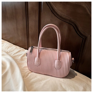 Detail of pink pleated cylinder handbag with dual handles and metal zipper puller