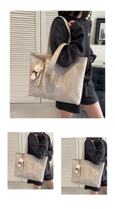 Detail of minimalist faux leather tote bag with H.SHAN logo and bear charm hanging