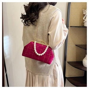 Détail du sac coquille en velours avec poignée en perles et bandoulière chaîne dorée