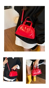 Close-up of heart-shaped relief on red patent leather dumpling handbag with silver hardware