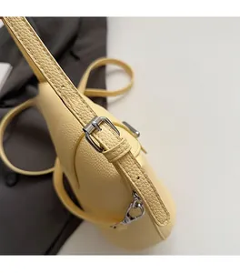 Close-up of pale yellow lychee texture leather with silver metal buckle detail