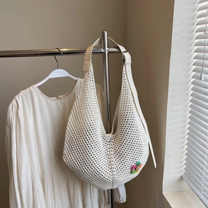 Close-up of cream mesh knit tote bag with colorful flower accent and leather strap