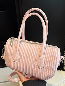 Pink cylinder crossbody bag with vertical pleated stitching and silver hardware
