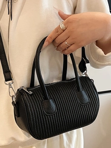 Retro black cylindrical crossbody bag with pleated texture and adjustable leather strap