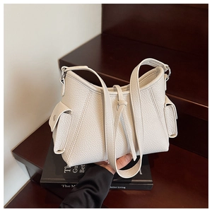 Detail view of the beige lychee pattern leather bag textured surface and side pockets