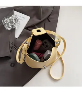 Top view of yellow bucket bag interior showing capacity for makeup and phone items